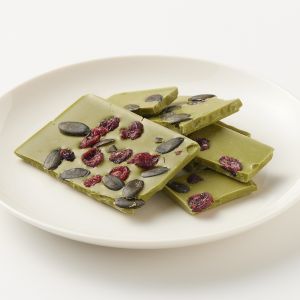 Chocolat blanc avec des canneberges sucr&eacute;es, des graines de citrouille et du th&eacute; vert matcha