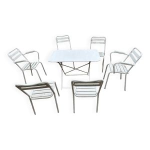 Salon de jardin en fer forgé et lattes de bois composé de deux fauteuils, 4 chaises  et d'une table.